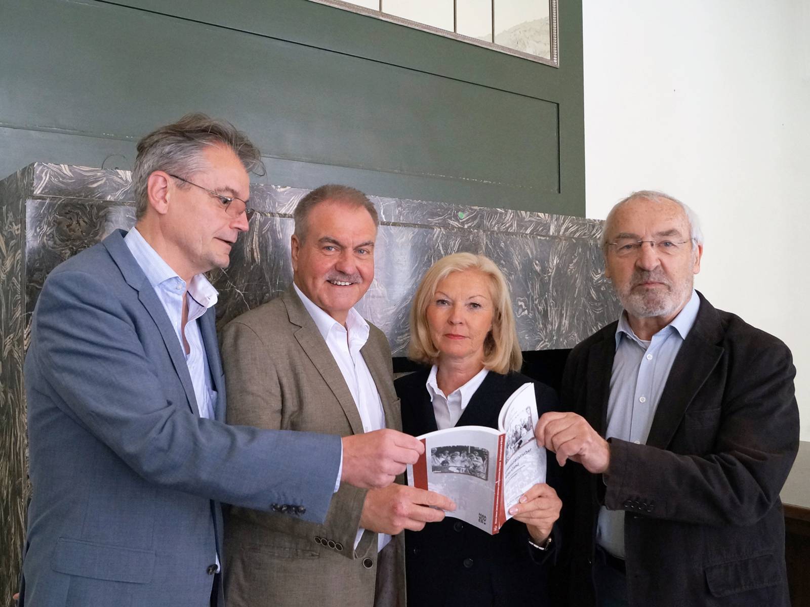Vier Personen präsentieren das Buch "Linkssozialistischer Widerstand gegen die nationalsozialistische Diktatur in Hannover"